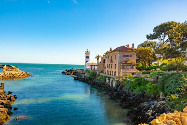 Colourful buildings in Cascais in front of the clear ocean