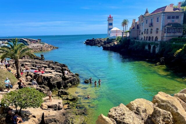 People sunbathing on a rocky beach in Cascais