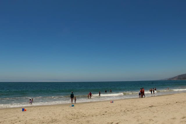 eople relaxing on the sand at Praia da Conceição in Cascais