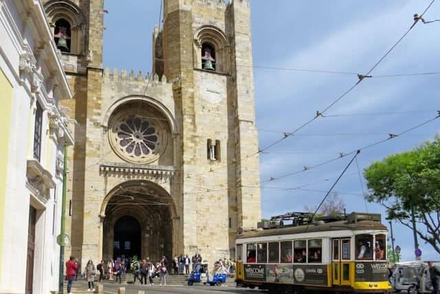 Lisbon Cathedral with a yellow tram passing in front