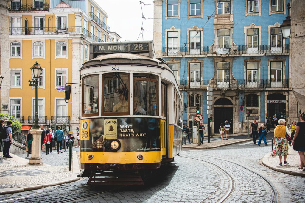 Lisbon’s iconic yellow Tram 28 passing through a traditional neighbourhood